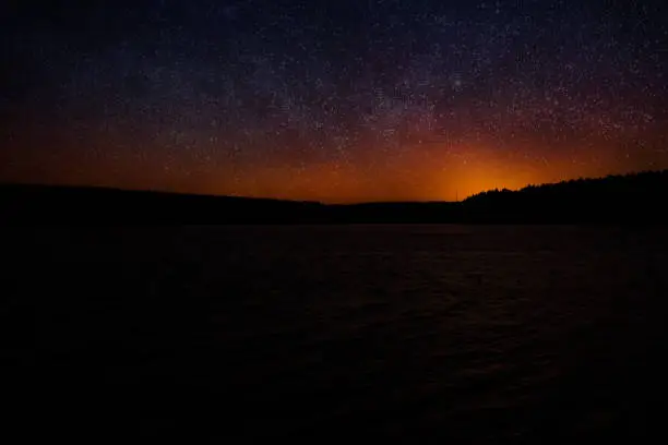 Starry sky in summer over a lake with milky way