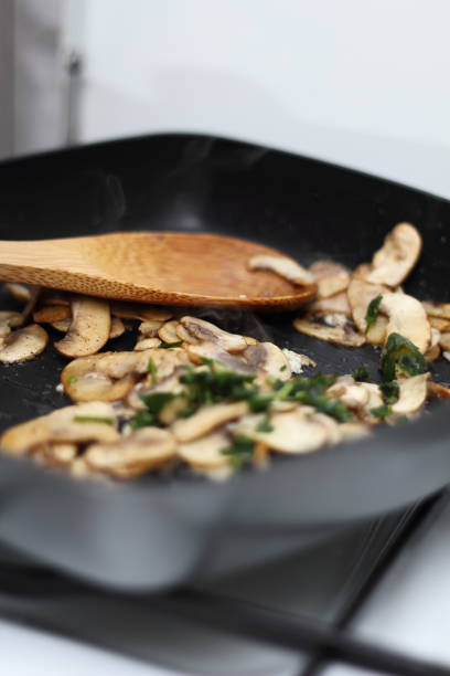 istock Fried champignon mushroom with parsley in skillet 1060143466