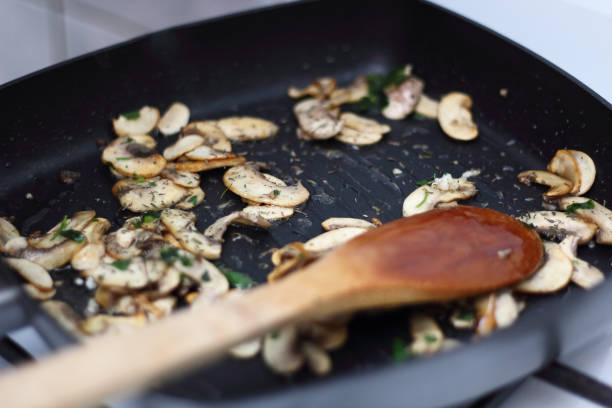 Fried champignon mushroom with parsley in skillet