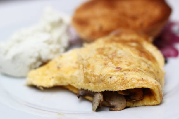 istock Omelette with fried champignon mushrooms, cottage cheese and toasted bread roll 1060145436