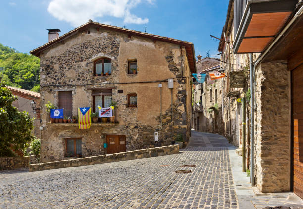 strada vuota con vecchi edifici in un piccolo villaggio castellfollit de la roca, spagna - sleeping volcano foto e immagini stock