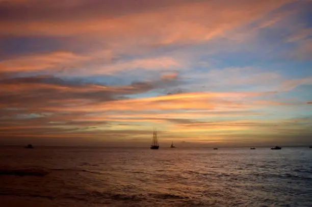 Boats lay at anchor as the sun sets on Paynes Bay, Barbados.