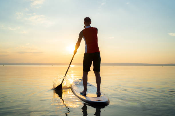 istock one man padleboarding alone on lake at sunset 1060154300