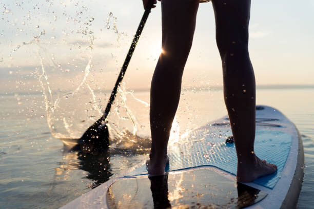 istock stand up paddling paddleboarding closeup woman sunset 1060154316