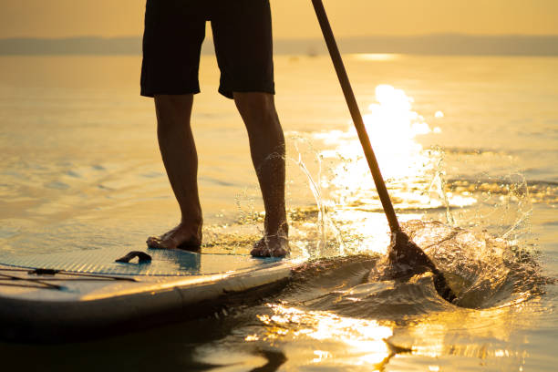 istock stand up paddling closeup man sunset 1060154336