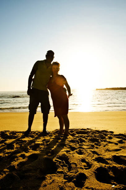 istock Together In Love: Silhouette Of A Young Couple On A Colourful Beachside 1060154448