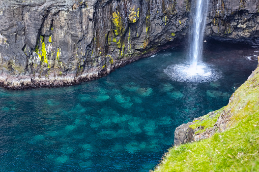 Detail of Mulafossur Waterfall. The little village Gasadalur on Faroe Islands with the Mulafossur Waterfall.