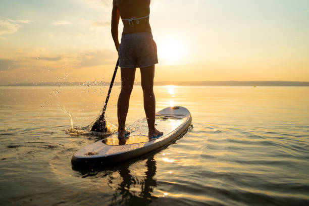 istock woman paddleboarding at sunset 1060156640