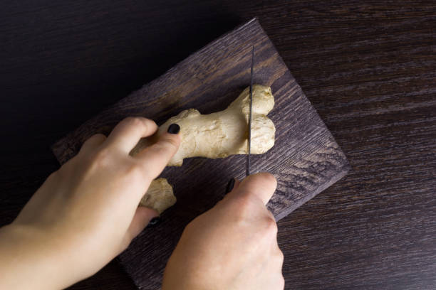 istock woman cut ginger on a wooden board 1060161218