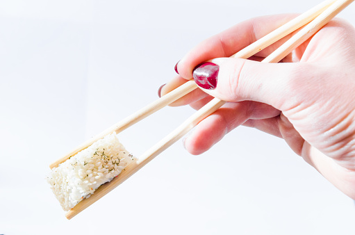 sushi on a white isolated background with chopsticks in hand