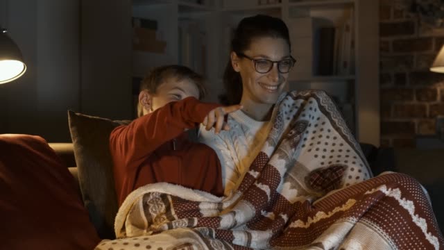 Mother and boy watching movies together on Christmas eve
