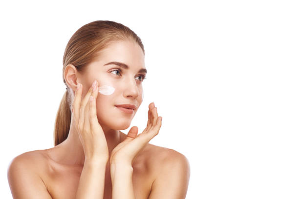 istock Beautiful womans left cheek with facecream close-up studio on white. 1060178738