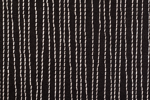Black fabric with white stitches background texture