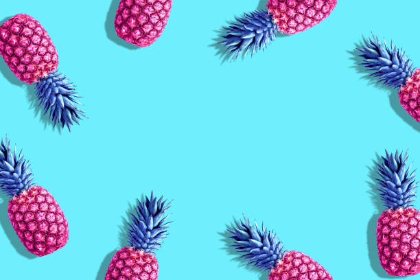 istock Pink painted pineapples on a vivid blue background. Minimal summ 1060193730