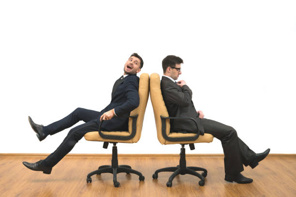 istock The two businessmen sit on chairs on the white wall background 1060199968