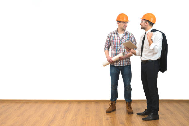 istock The two men in helmets stand with a tablet on the white wall background 1060201324