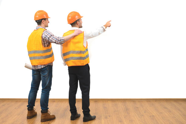 istock The two builders gesture on the white wall background 1060201350