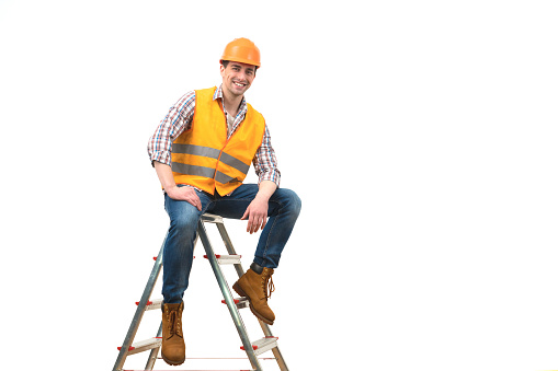 The happy builder sitting on the ladder on the white background