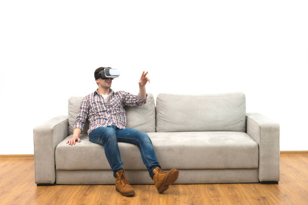 istock The man in virtual glasses sitting on the sofa on the white wall background 1060203584