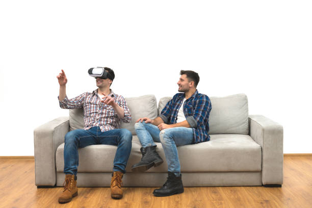 istock The two men with virtual glasses sit on a sofa on the white wall background 1060203840