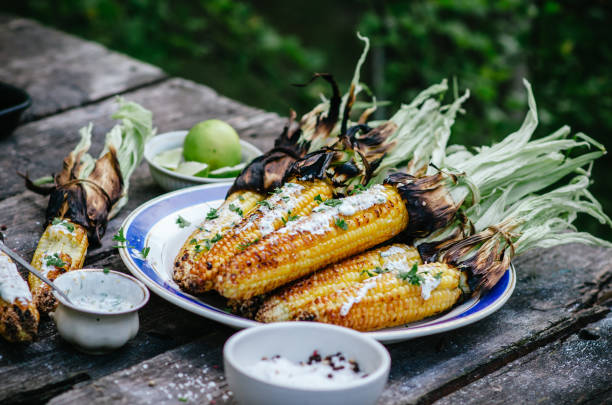 맛 있는 구운된 옥수수 cobs 허브 버터와 라임 야외에서 나무 테이블에 오래 된 테이블에. - grilled corn vegetable corn on the cob 뉴스 사진 이미지