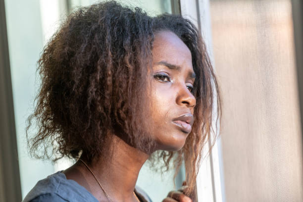 istock Serious young beautiful black woman looking through a window 1060210230