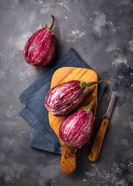 istock Fresh striped purple aubergines on grey background 1060210408