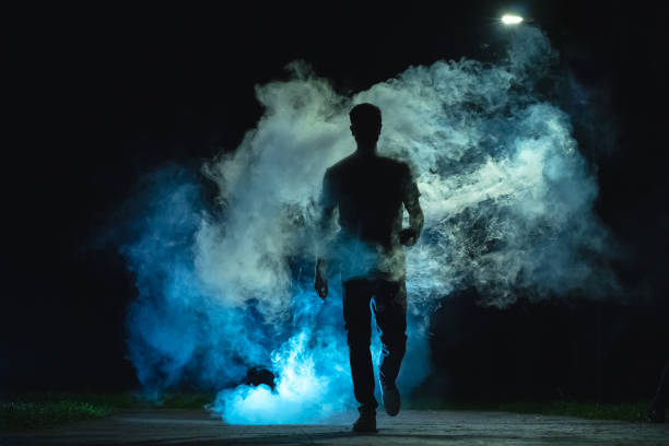 istock The man walking in the blue smoke on the dark background 1060212640