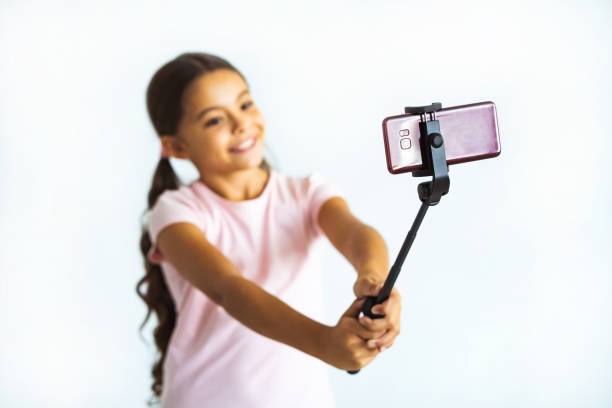 istock The smiling girl taking selfie on the white wall background 1060214868