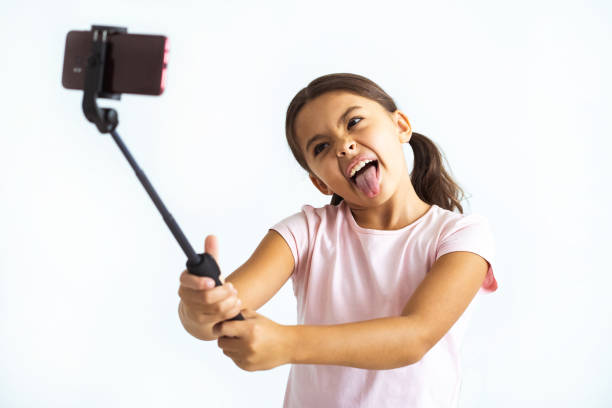 das kleine mädchen nehmen selfie auf die weiße wand-hintergrund - telephone child isolated on white elegance stock-fotos und bilder