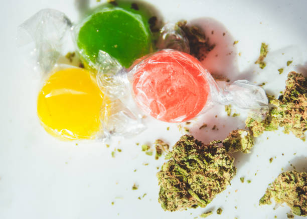 Marijuana infused hard candies Marijuana buds and plastic wrapped THC/CBD infused hard candies bud candy stock pictures, royalty-free photos & images