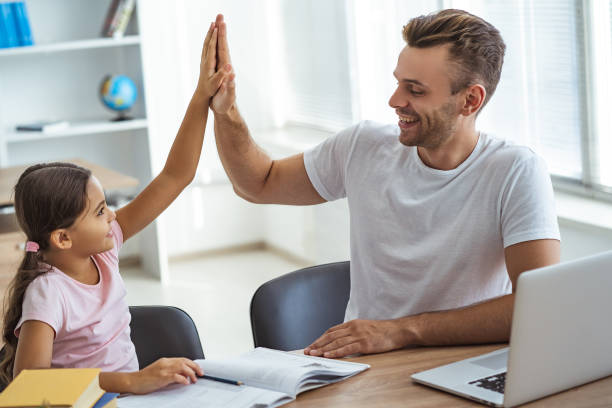 istock The happy father and a daughter sitting at the desk and gesturing 1060219528