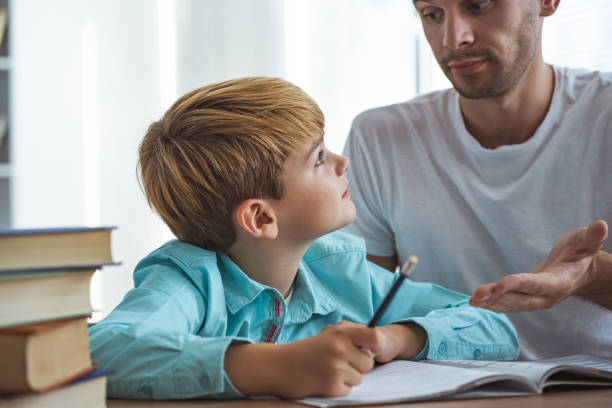 istock The happy father and a son doing homework at the desk 1060219620