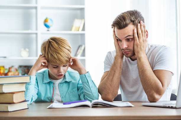 istock The tired father and a son doing homework at the desk 1060219644