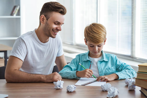 el feliz padre y un hijo sentados en el escritorio y dibujo en el papel - little boys measuring expressing positivity intelligence fotografías e imágenes de stock