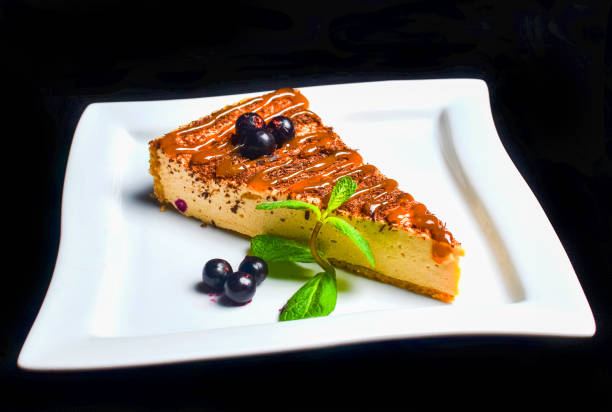 istock Chocolate cheesecake with blueberries and mint on a plate isolated on a black background. 1060220198