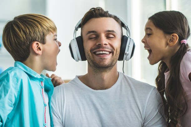 the man near kids listening music in headphone - emotional stress looking group of people clothing imagens e fotografias de stock
