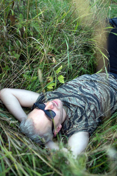 istock A young handsome bearded blonde guy wearing black sunglasses lying on the grass and looking up to sky. 1060222082
