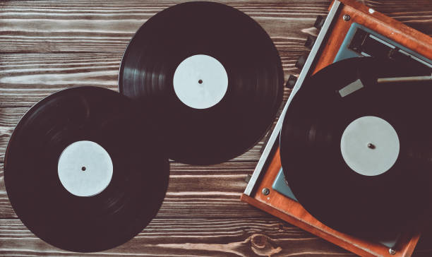 istock Gramophone and vinyl discs on a wooden floor. Retro media 1060222576