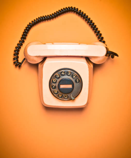 istock A rotary retro phone on a yellow background. Top view. 1060223024