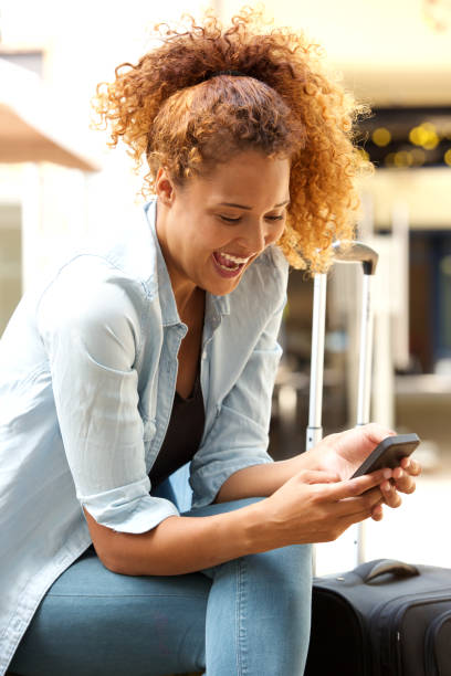 istock attractive young woman laughing at text message outside 1060224630