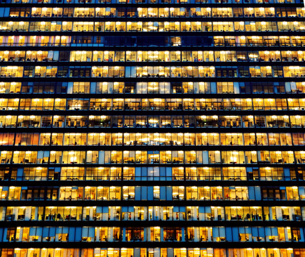 istock Workers working late. Business finance building. Office windows by night. 1060224718