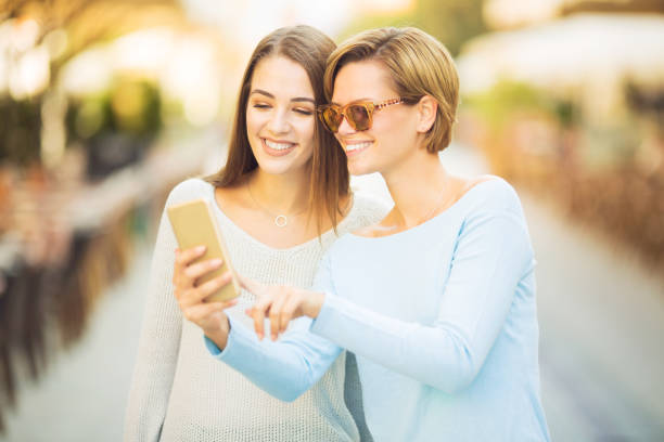 istock Young women looking at the phone and laughing 1060231488