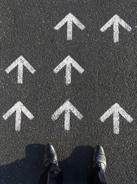 istock The way forward: Man looking at arrow signs on the ground 1060231620