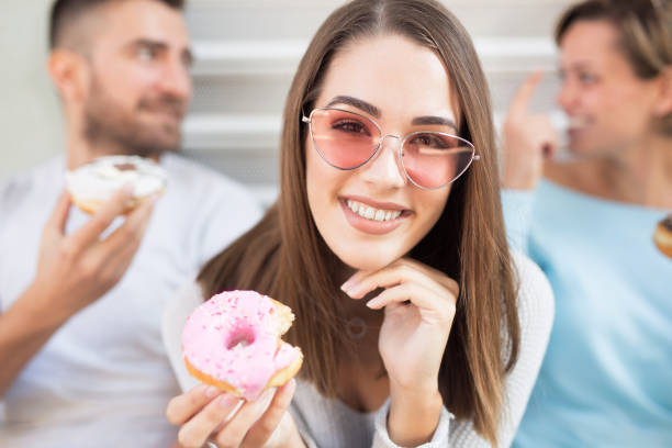 istock Beautiful young woman eating a donut 1060233544