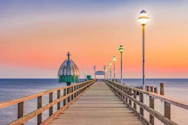 bright Baltic Sea beach and the Pier Zinnowitz in the Hintergrudn in front of an orange sky