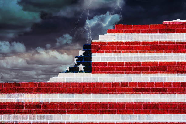 American flag on broken brick wall with stormy sky background