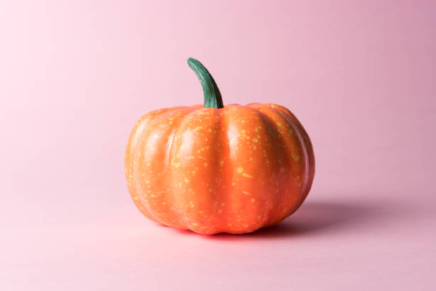 istock Halloween pumpkin on pastel pink background. Halloween minimal concept. 1060247428