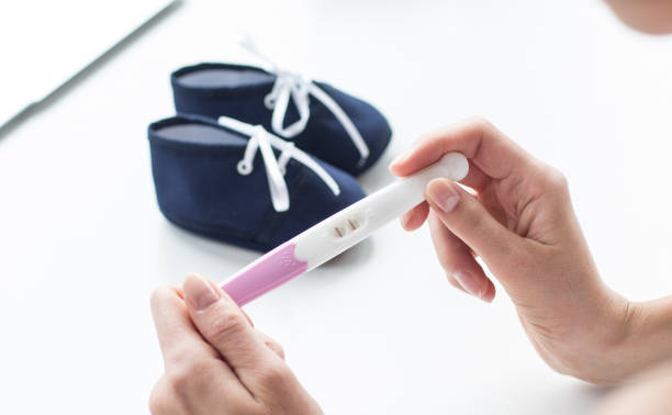 istock Woman holding on her hands pregnancy test. 1060252100