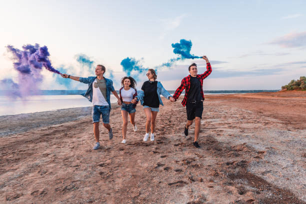 istock young friends running with hand flare or fusee 1060257418
